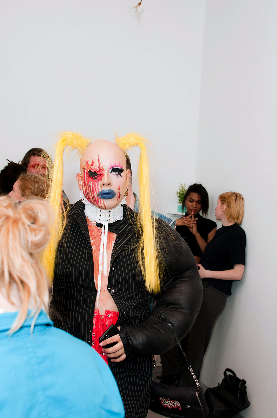JPEG Papi in a crowd wearing long blonde pigtails and a bloody face prosthetic
